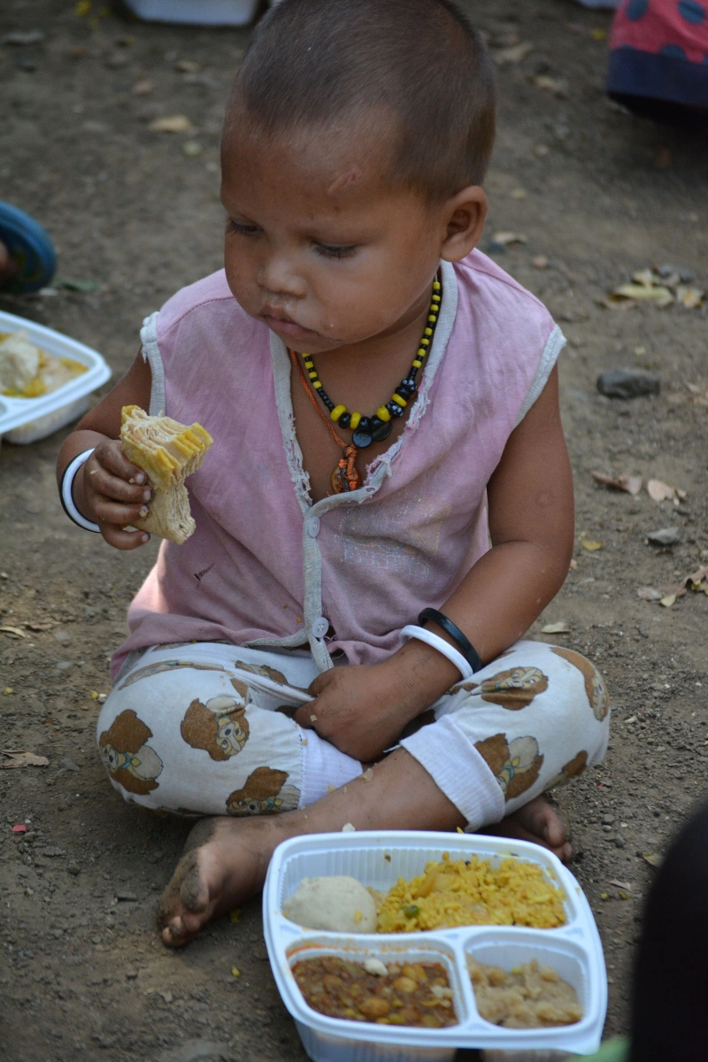 Toddler eating prasadam